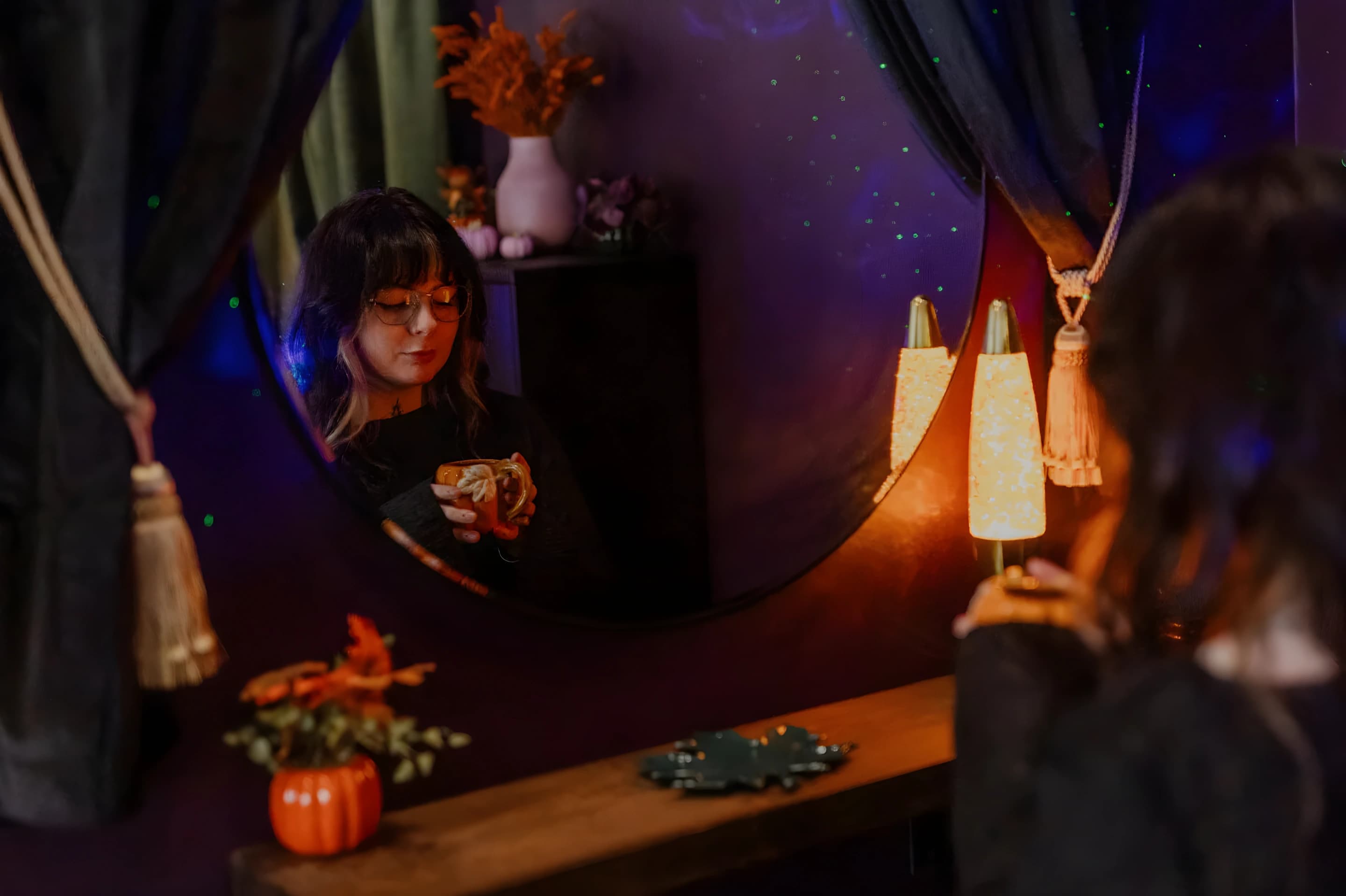 The salon at night, lit by lamps and a mirror