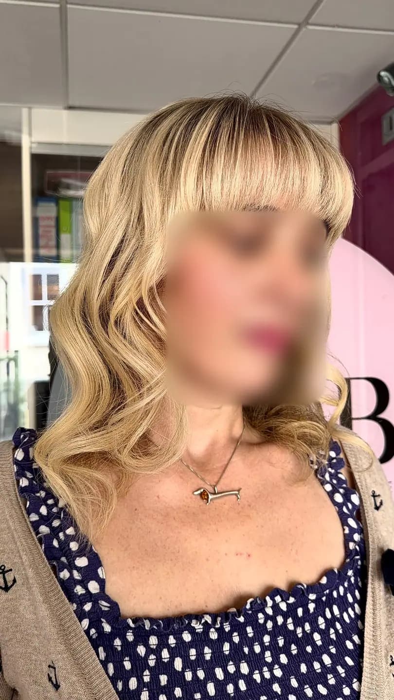 After: full blonde waves with a fringe