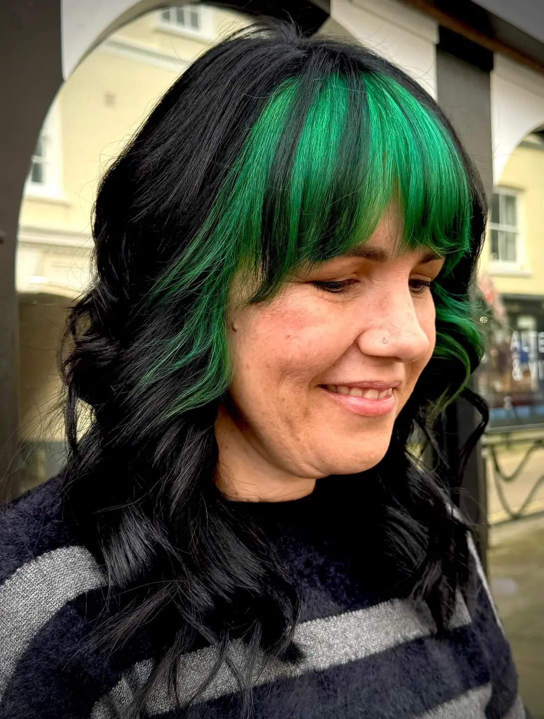 A green money piece framing the face over black waves