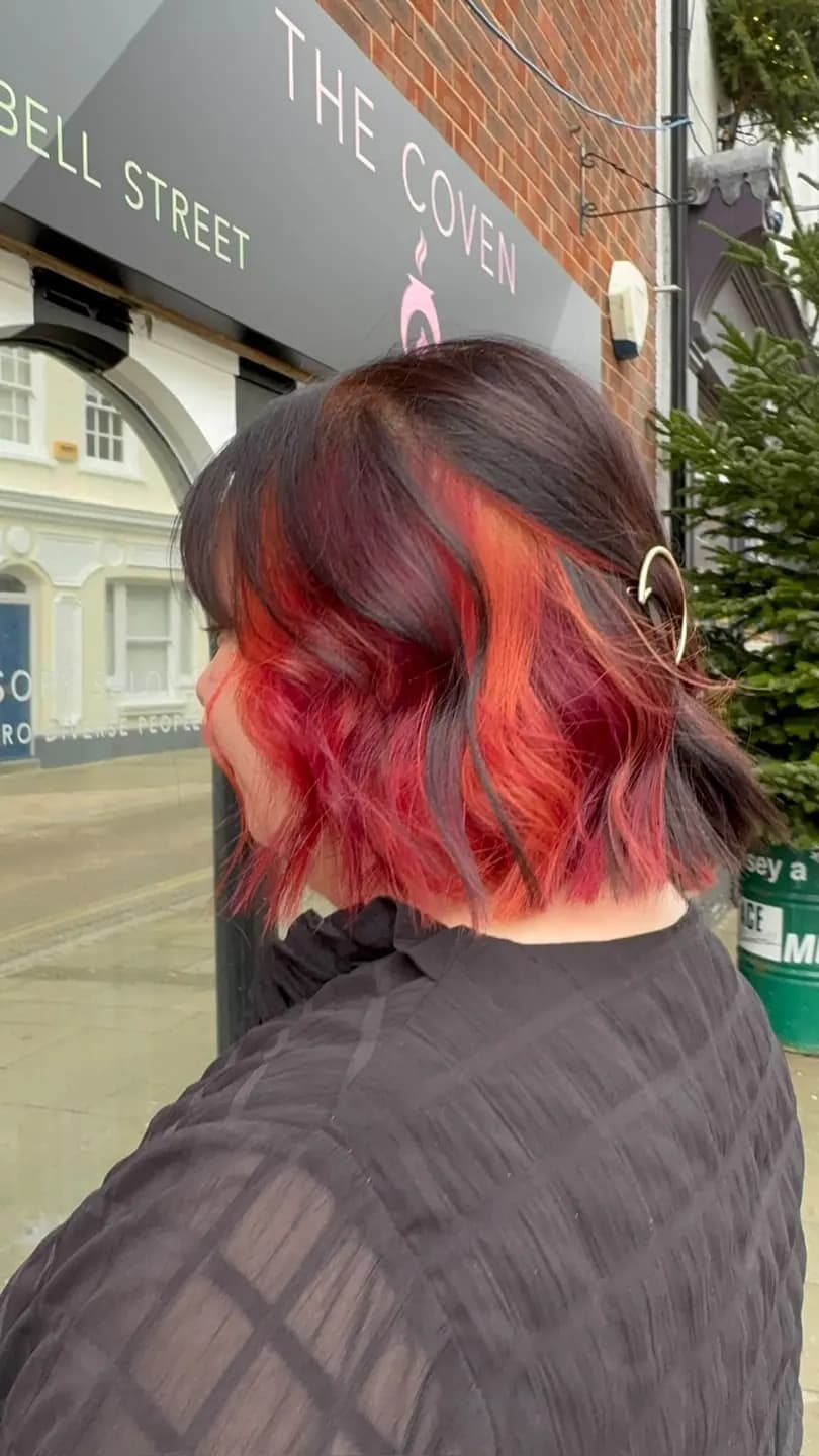 Peekaboo red showing through a dark bob